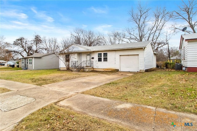 view of front of property with cooling unit, a garage, and a front yard