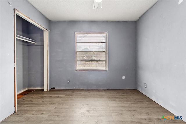 unfurnished bedroom with light hardwood / wood-style floors, a closet, and ceiling fan