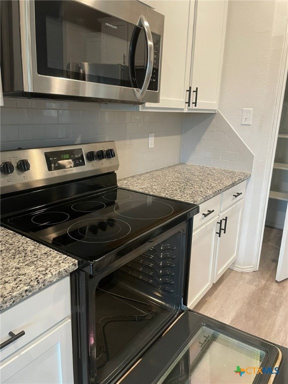 2411 Pintail Loop, Copperas Cove, TX 76522 - kitchen featuring stainless steel appliances, white cabinetry, backsplash, light stone counters, and light wood finished floors