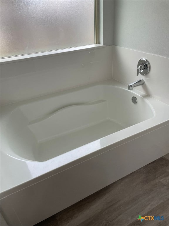 2411 Pintail Loop, Copperas Cove, TX 76522 - bathroom featuring a garden tub and wood finished floors