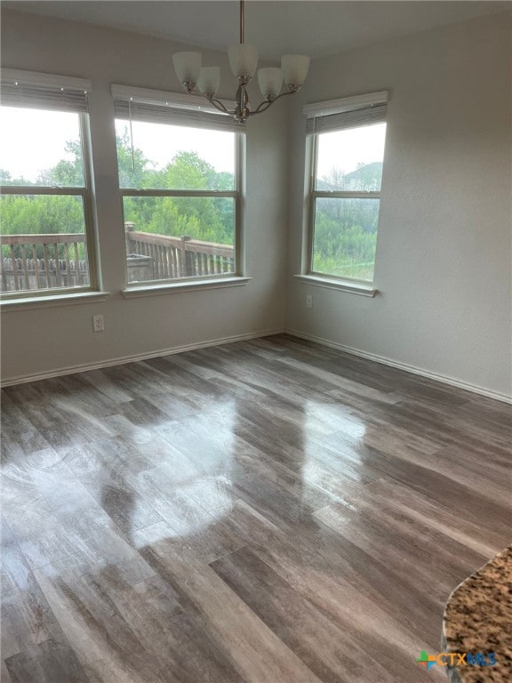 2411 Pintail Loop, Copperas Cove, TX 76522 - empty room with wood finished floors, a chandelier, and baseboards