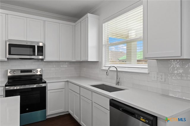 619 Killam Dr, Temple, TX 76502 - kitchen featuring appliances with stainless steel finishes, a sink, light countertops, white cabinetry, and backsplash