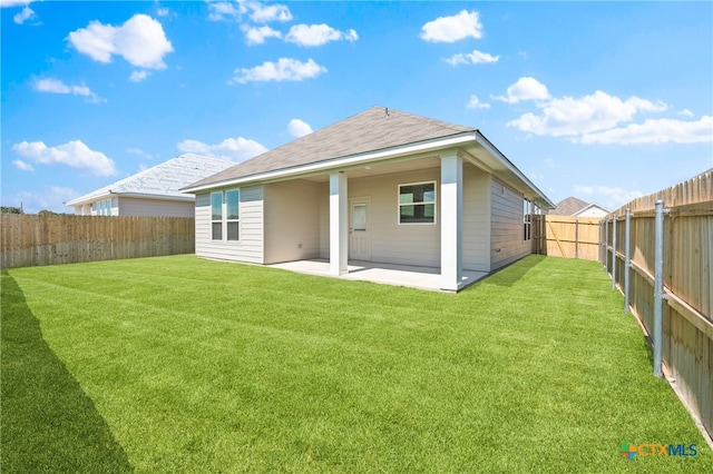 rear view of house with a lawn and a patio area