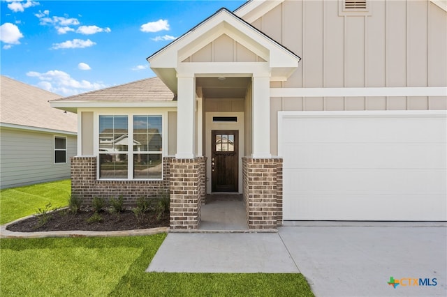 doorway to property with a lawn and a garage