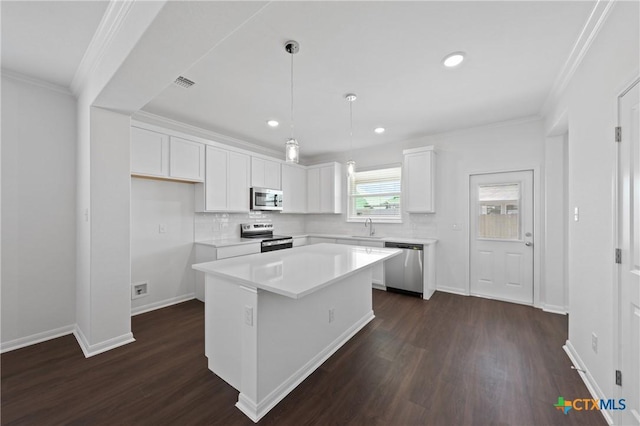 619 Killam Dr, Temple, TX 76502 - kitchen with appliances with stainless steel finishes, a sink, a kitchen island, white cabinetry, and ornamental molding