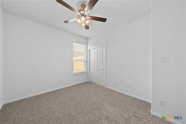 empty room featuring carpet flooring and ceiling fan