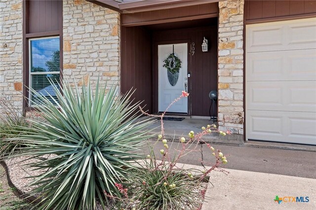 907 Great Oaks Cv, Round Rock, TX 78681 - doorway to property with stone siding and a garage