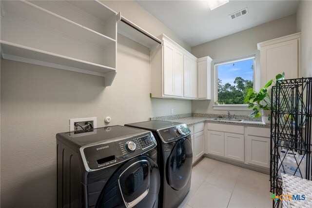 916 Dream Catcher Dr, Leander, TX 78641 - washroom with washing machine and clothes dryer, cabinet space, and light tile patterned floors