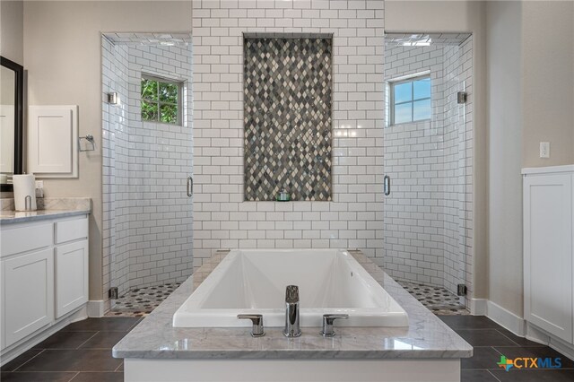916 Dream Catcher Dr, Leander, TX 78641 - full bath with healthy amount of natural light, a bath, tile patterned flooring, and a shower stall