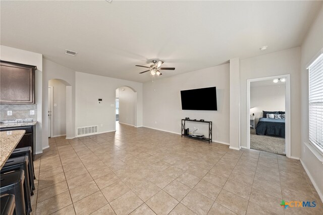 unfurnished living room with ceiling fan and light tile patterned flooring