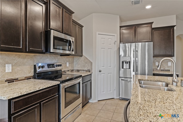 kitchen with tasteful backsplash, sink, light tile patterned floors, and stainless steel appliances