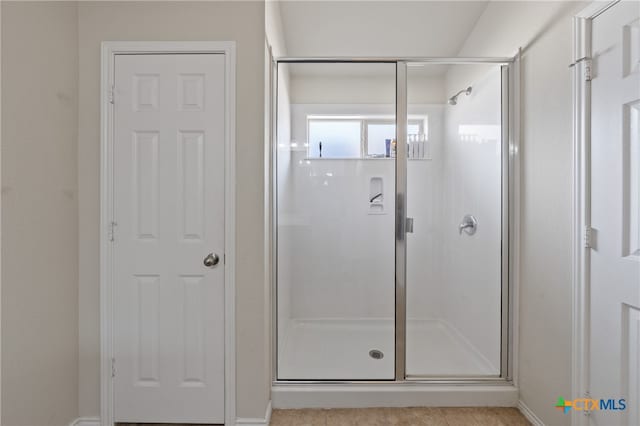 bathroom with a shower with door