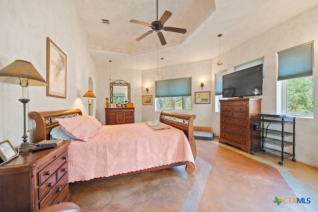 bedroom with ceiling fan and a raised ceiling