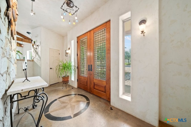 foyer entrance with french doors and an inviting chandelier