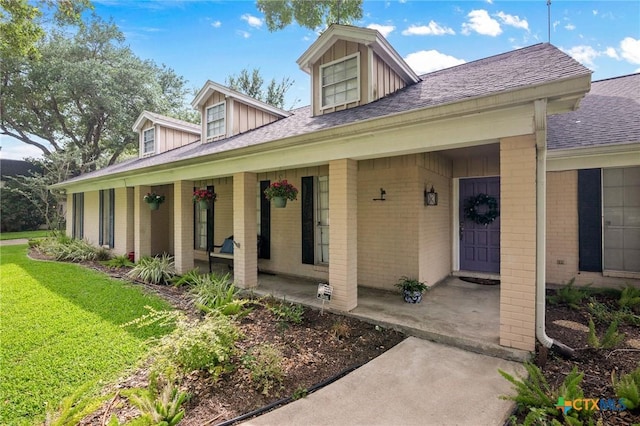 407 Pasadena Dr, Victoria, TX 77904 - view of front facade featuring brick siding, a porch, a front lawn, and roof with shingles