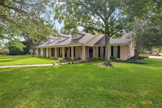 407 Pasadena Dr, Victoria, TX 77904 - view of front of house featuring a front yard, a porch, and a shingled roof