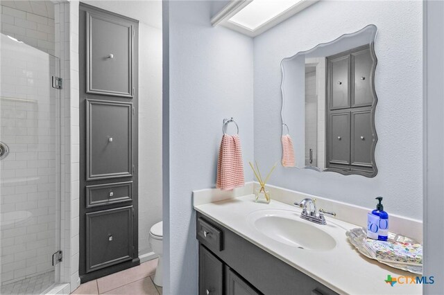 407 Pasadena Dr, Victoria, TX 77904 - bathroom featuring vanity, a stall shower, toilet, and tile patterned floors