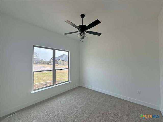 unfurnished room featuring a ceiling fan, light colored carpet, and baseboards