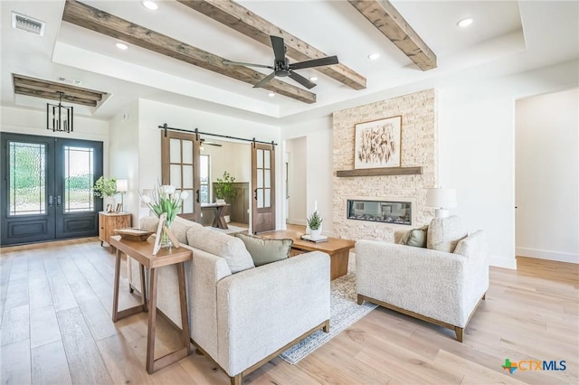 1586 Bosque Lago Dr, Belton, TX 76513 - living area featuring a barn door, light wood-style flooring, a ceiling fan, french doors, and beam ceiling