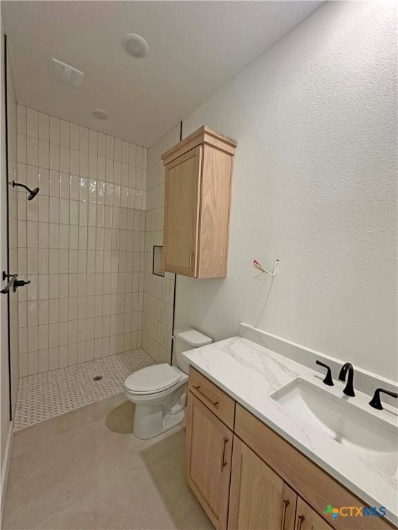 bathroom with vanity, a shower stall, and toilet