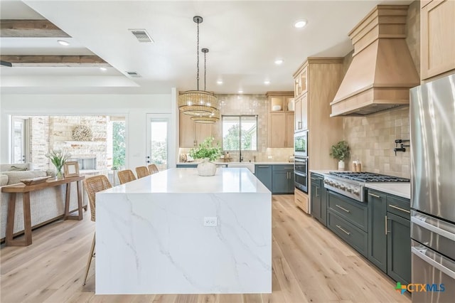 1586 Bosque Lago Dr, Belton, TX 76513 - kitchen featuring stainless steel appliances, a chandelier, custom exhaust hood, light wood-style floors, and a kitchen island