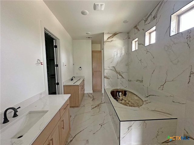 bathroom featuring marble finish floor, two vanities, a sink, and visible vents