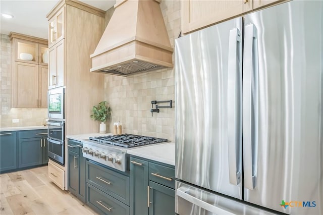 1586 Bosque Lago Dr, Belton, TX 76513 - kitchen featuring appliances with stainless steel finishes, premium range hood, decorative backsplash, light countertops, and glass insert cabinets
