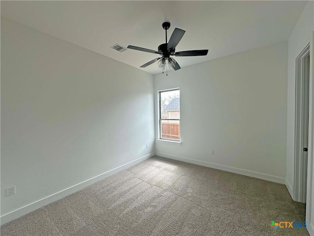 spare room with a ceiling fan, carpet, visible vents, and baseboards