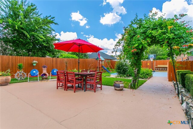 1306 Falcon Trl, Copperas Cove, TX 76522 - fenced backyard featuring a playground, a patio area, and outdoor dining space