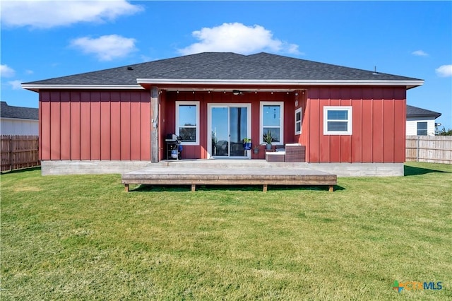 back of house featuring a lawn and a deck