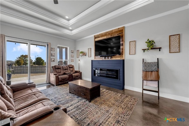 living room with a fireplace, a raised ceiling, and crown molding