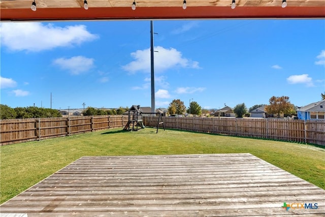 deck featuring a playground and a lawn