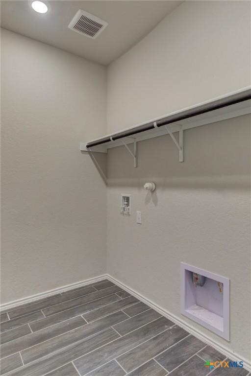 2420 Dielman Dr, Seguin, TX 78155 - laundry area with hookup for a gas dryer, hookup for a washing machine, wood tiled floors, baseboards, and recessed lighting