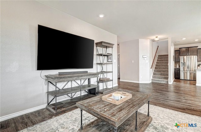 living area with recessed lighting, stairway, baseboards, and wood finished floors