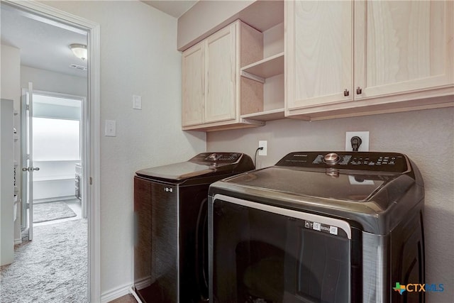 laundry area with visible vents, baseboards, cabinet space, carpet flooring, and washing machine and dryer