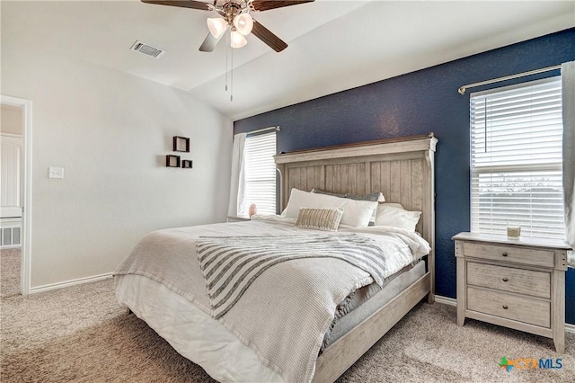 bedroom featuring lofted ceiling, baseboards, visible vents, and light carpet