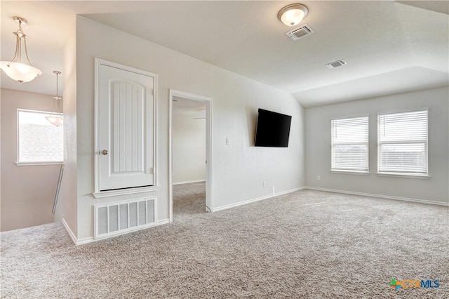 unfurnished living room featuring vaulted ceiling, visible vents, and carpet floors