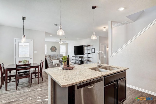 kitchen with visible vents, light wood-style flooring, a sink, dishwasher, and decorative light fixtures