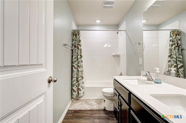 bathroom with visible vents, shower / bathtub combination with curtain, toilet, a sink, and wood finished floors