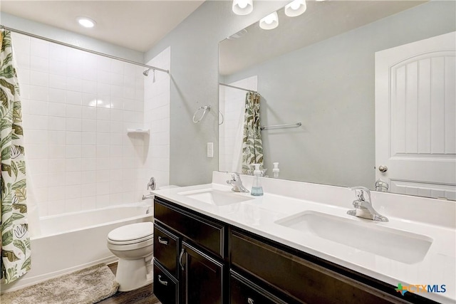 full bathroom with a sink, shower / bath combo with shower curtain, toilet, and double vanity