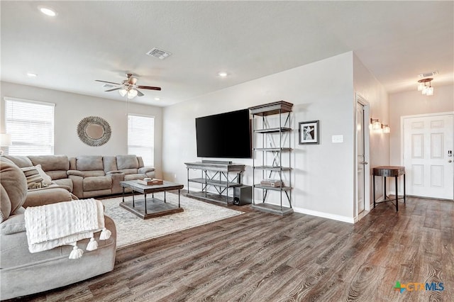 living room with a ceiling fan, wood finished floors, visible vents, and baseboards