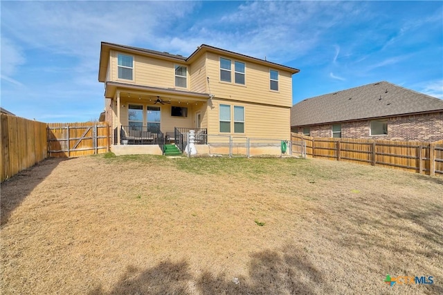 rear view of property featuring a fenced backyard, a patio, a lawn, and ceiling fan