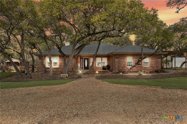 ranch-style home with brick siding, a chimney, and a front yard