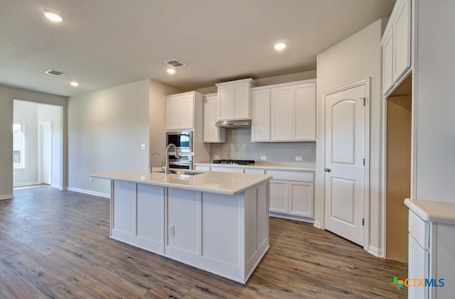 kitchen featuring white cabinetry, sink, stainless steel gas cooktop, light hardwood / wood-style floors, and a center island with sink