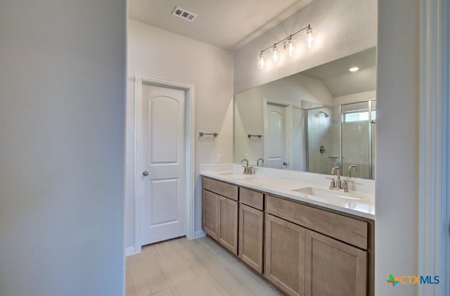 bathroom with a shower with door and vanity