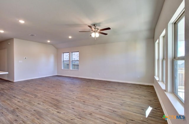 empty room with hardwood / wood-style flooring, ceiling fan, and lofted ceiling