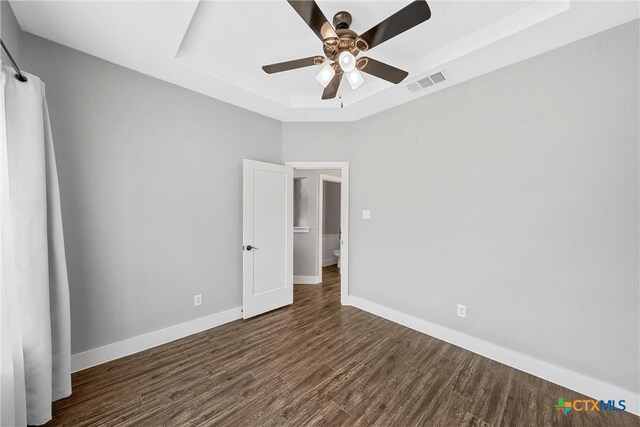 4130 Cripple Creek Dr, Temple, TX 76502 - unfurnished bedroom featuring a ceiling fan, wood finished floors, a tray ceiling, baseboards, and visible vents