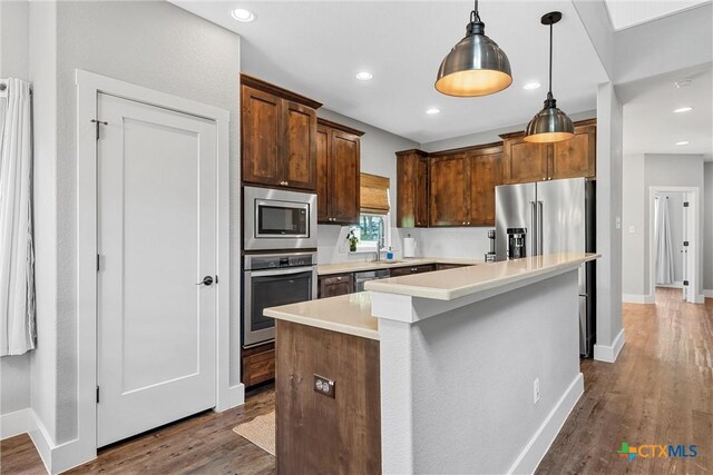 4130 Cripple Creek Dr, Temple, TX 76502 - kitchen with light countertops, baseboards, pendant lighting, appliances with stainless steel finishes, and dark wood-style flooring