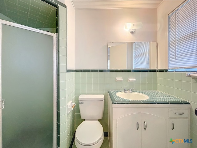 bathroom featuring walk in shower, crown molding, toilet, vanity, and tile walls