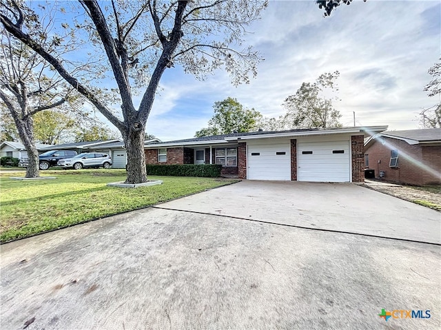 ranch-style home featuring a garage and a front lawn